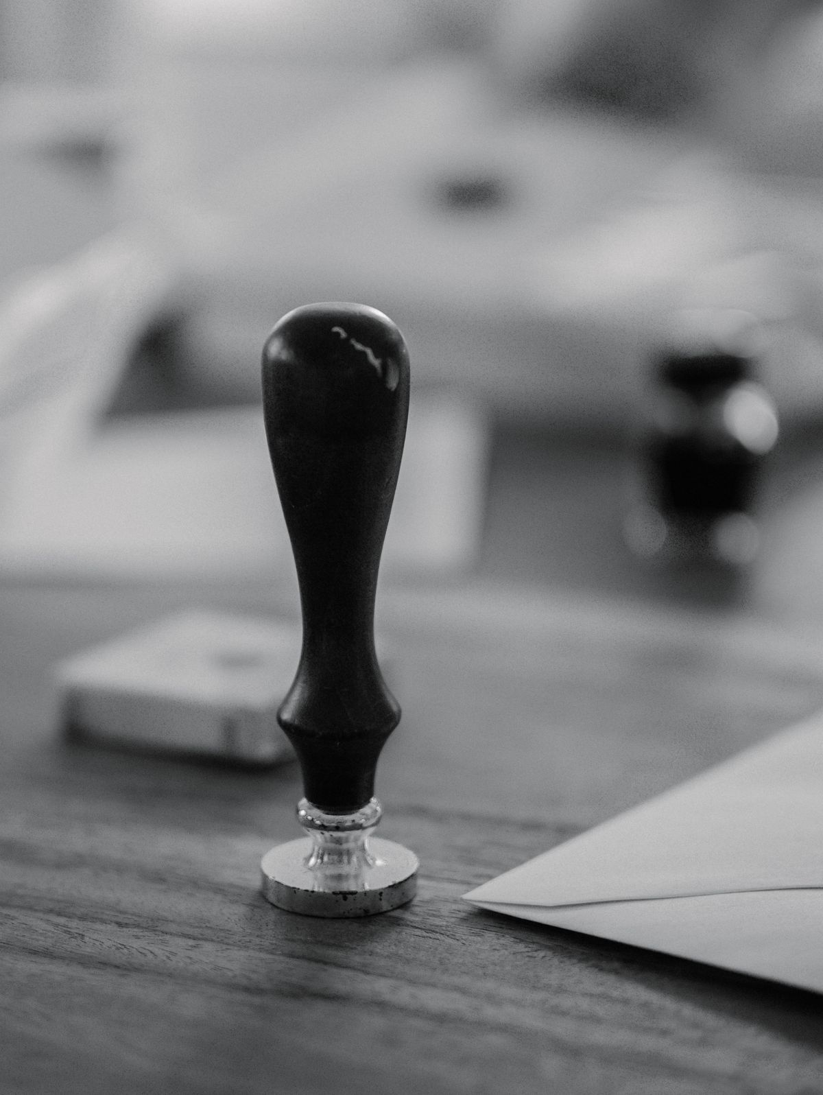 A notary's wax-seal stamp resting on a wooden desk