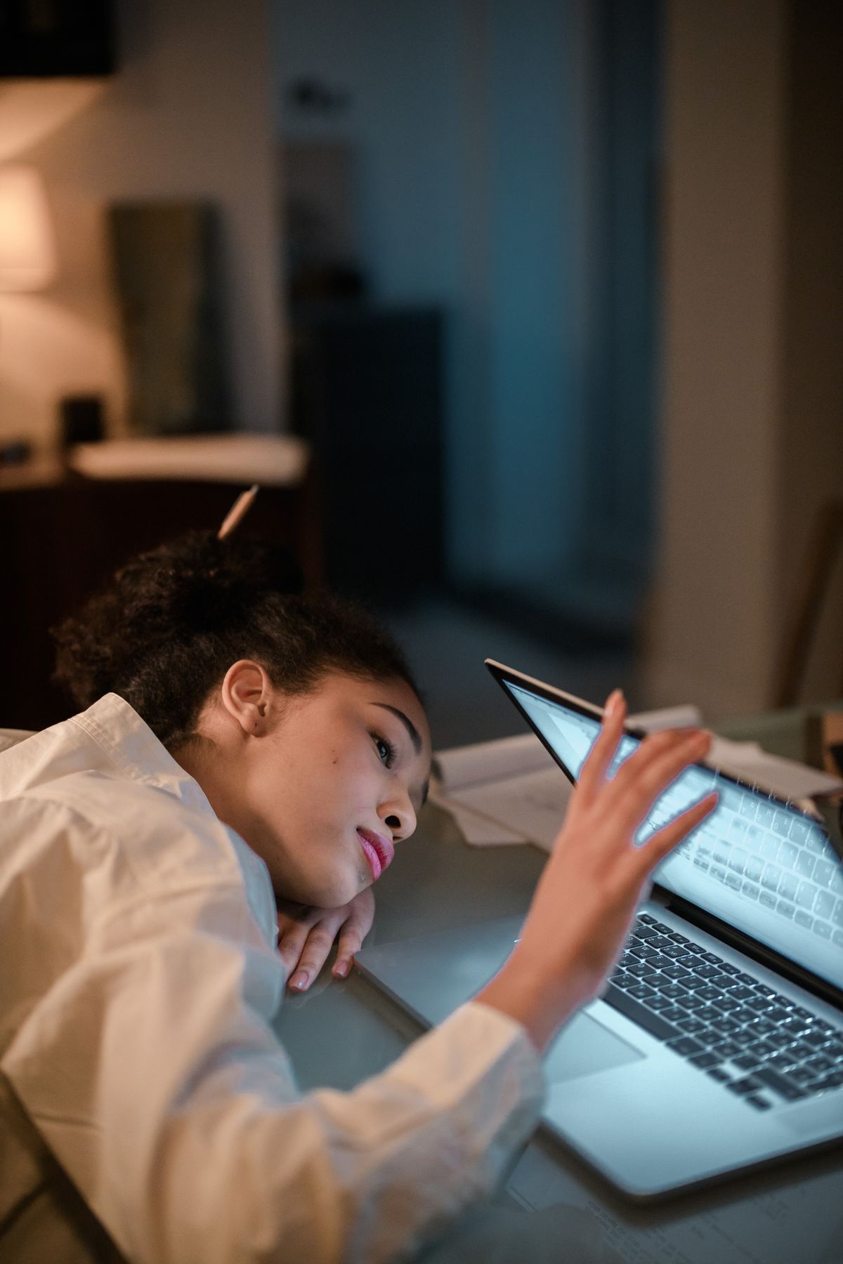A tired woman resting near her laptop after a long day of work